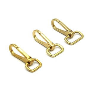 May include: Three gold-toned metal clasps with a hook and a rectangular loop. The clasps are arranged in a row on a white background.