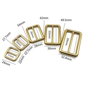 Peut inclure: Assortiment de boucles de ceinture en métal doré de différentes tailles. Les boucles sont rectangulaires avec une barre centrale. Les dimensions de chaque boucle sont indiquées en millimètres.