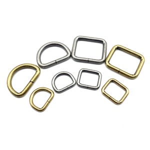 Op de afbeelding: Assortiment van zilveren en gouden metalen D-ringen en vierkante ringen. Deze ringen worden vaak gebruikt om banden, handvatten of andere hardware aan tassen, riemen of andere lederwaren te bevestigen.