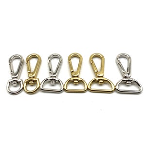 May include: Five metal swivel clasps, two gold and three silver, for attaching to bags, straps, or other accessories.