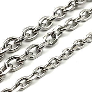 May include: Three silver chains of different sizes, each with oval-shaped links. The chains are arranged in a staggered pattern, with the largest chain at the top and the smallest chain at the bottom.