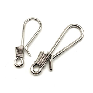 May include: Two silver swivel hooks with a spring coil on the top of each hook.