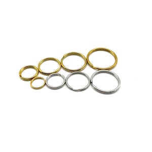 Pode incluir: Conjunto de argolas de chave em diferentes tamanhos. As argolas de chave são feitas de metal e vêm em dourado e prateado.