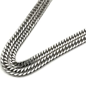 Pode incluir: Um colar de corrente curb prateado com um design clássico. A corrente é feita de metal durável e tem um acabamento polido.