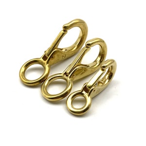 May include: Three gold-colored metal snap hooks of different sizes. The hooks are numbered 0, 1, and 2.