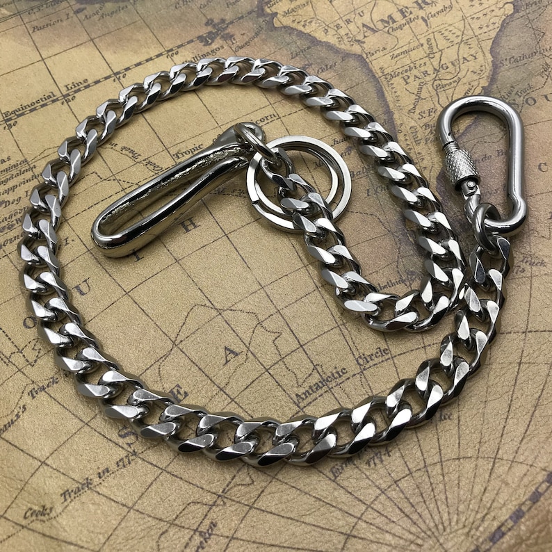 May include: A silver-colored chain with a hook and a carabiner clip. The chain is made of interlocking links and is displayed on a vintage map background. The hook and clip are both shiny and metallic.