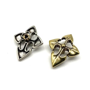May include: Two decorative metal flower-shaped embellishments. One is silver with a gold centre, the other is gold. Both have a hole in the centre.