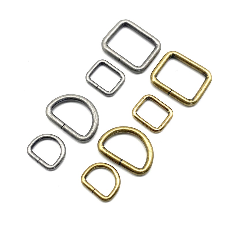 Op de afbeelding: Assortiment van zilveren en gouden metalen D-ringen en vierkante ringen. De ringen zijn in verschillende maten.