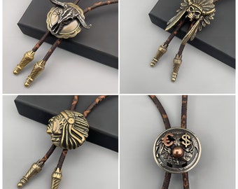 May include: Four different bolo ties with various metal designs. The designs include a skull with feathers, a bull skull, a Native American chief, and a skull with dollar and euro symbols.