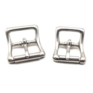 May include: Two silver metal belt buckles with a rectangular shape and a smooth finish.
