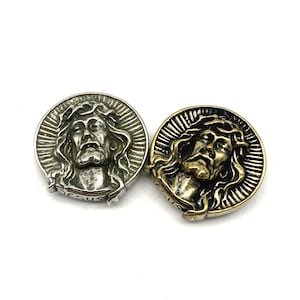 Könnte beinhalten: Zwei runde Metall-Anhänger mit einem detaillierten Bild von Jesus Christus mit Dornenkrone. Ein Anhänger ist silberfarben, der andere goldfarben.