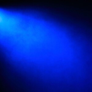 May include: A bright blue spotlight shines from the upper left corner, casting a vibrant beam across a dark background. The light source is a small, circular shape, creating a dramatic contrast.