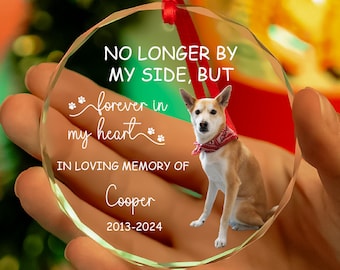 May include: A clear glass ornament with a red ribbon, featuring a photo of a dog and the text "NO LONGER BY MY SIDE, BUT forever in my heart IN LOVING MEMORY OF Cooper 2013-2024".
