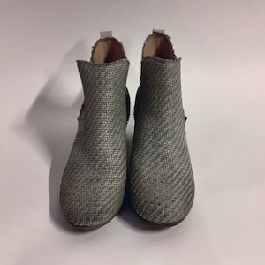 May include: A pair of gray woven ankle boots with a pointed toe.