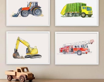 Op de afbeelding: Vier ingelijste aquareldrukken met bouw- en hulpverleningsvoertuigen: een oranje tractor, een groen-gele vuilniswagen, een gele graafmachine en een rode brandweerwagen. Een kleine houten speelgoedtruck staat op het oppervlak onder de kunst.