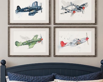 May include: A set of four framed watercolor prints featuring vintage military aircraft, including a dark blue fighter, a twin-engine plane, a green fighter with shark teeth markings, and a silver plane with red accents, displayed in a bedroom setting.