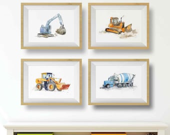 May include: Four framed watercolor prints of construction vehicles. The prints feature a blue excavator, an orange bulldozer, a yellow front-end loader, and a blue cement mixer truck. Each print is in a light brown wooden frame.