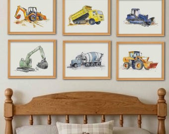May include: A set of six framed watercolor prints featuring construction vehicles including an orange excavator, a yellow dump truck, a blue bulldozer, a green excavator, a blue cement mixer, and a yellow front loader, all displayed in light wood frames.