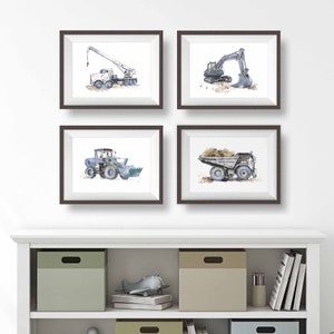 Lifestyle photo of set of 4 construction truck prints in blue gray. A boom truck, excavator, wheel front loader and dump truck are shown.