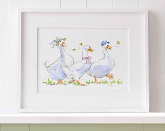 May include: A framed watercolor print featuring three white ducks walking in a line on green grass. The first duck wears a straw hat with blue ribbons, the second a pink bow, and the third a blue cap. Small yellow flowers are scattered around.
