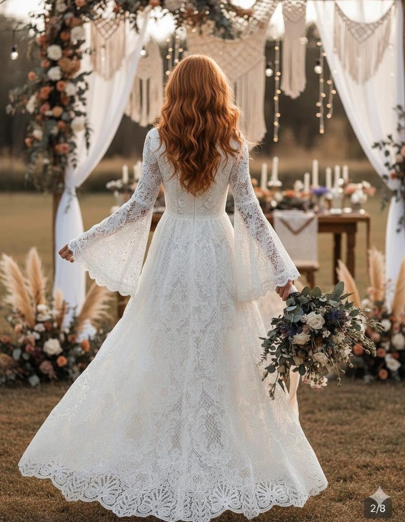 May include: A white lace wedding dress with long, flared sleeves and a detailed hem. The bride is holding a bouquet of flowers. The background includes floral arrangements and decorative macrame.