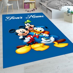 May include: A blue rug with a cartoon image of Mickey Mouse, Donald Duck, and Goofy. The rug has the text 'Your Name' at the top.