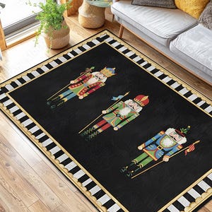 May include: Black rectangular area rug featuring three colorful nutcracker soldier figures. The rug has a black background with a white and gold border. The nutcrackers are in red, green, and blue uniforms.