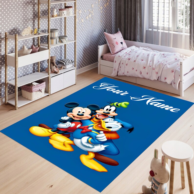 May include: A blue rug with a cartoon image of Mickey Mouse, Donald Duck, and Goofy. The rug has the text 'Your Name' in white text on the top right corner.