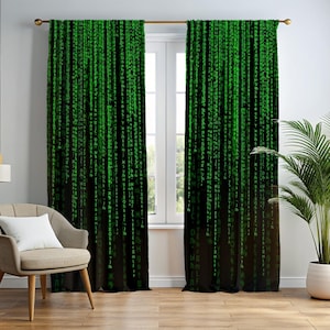 Può includere: Tende nere con un motivo a pioggia digitale verde. Le tende sono appese davanti a una finestra. Davanti alle tende c'è una sedia beige con un cuscino bianco. Le tende sono realizzate in tessuto scuro.