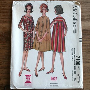 May include: Vintage McCall's sewing pattern for a Misses' and Junior Robe Set, size 12-13-14. The pattern is printed on white paper with a red, white, and blue color scheme. The pattern features three women wearing different styles of robes.