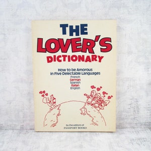 May include: A vintage book titled "The Lover's Dictionary" with red and blue text on a cream-colored cover. The book's subtitle reads "How to be Amorous in Five Delectable Languages." The cover features illustrations of people and hearts.
