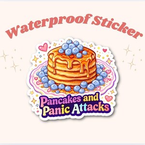 May include: A waterproof sticker featuring a stack of pancakes with blueberries and syrup. The sticker has the text "Pancakes and Panic Attacks" in a colorful design. The words "Waterproof Sticker" are arched above the pancakes.