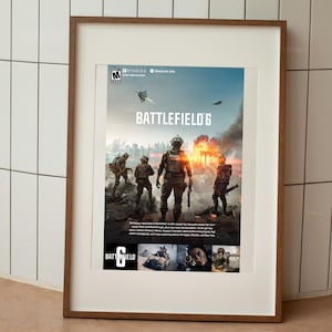 May include: Framed poster for Battlefield 6 video game. The image features soldiers in combat gear, with a fiery explosion in the background. The game's title is prominently displayed, along with the game's logo and the rating.