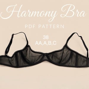 Peut inclure: Soutien-gorge noir transparent avec bretelles réglables et bordure en dentelle. Le texte "Harmony Bra" est affiché en écriture cursive. Le soutien-gorge est une taille 38, disponible en bonnets AA, A, B et C. Fond neutre.