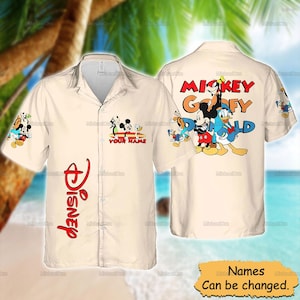 Peut inclure: Chemise boutonnée de couleur crème avec les personnages Disney Mickey, Dingo, Donald et Pluto. La chemise porte le logo Disney en rouge et le texte "YOUR NAME" sur le devant. Le dos de la chemise porte le texte "Mickey, Goofy, Donald".