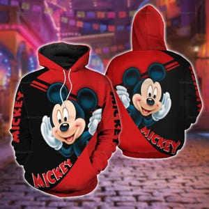 Puede incluir: Una sudadera con capucha roja y negra que presenta un gráfico de Mickey Mouse en la parte delantera y trasera. El diseño incluye la palabra MICKEY en letras rojas llamativas, cordones blancos y una capucha. La prenda muestra un patrón repetido.
