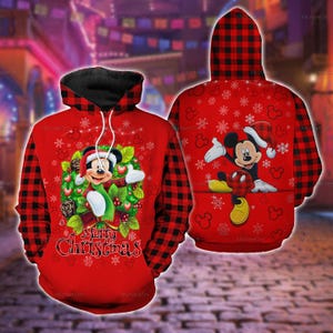 Könnte beinhalten: Ein roter Kapuzenpullover mit schwarz-rotem Karomuster an Kapuze und Ärmeln. Die Vorderseite zeigt Mickey Mouse in einem Weihnachtskranz mit dem Text Merry Christmas. Die Rückseite zeigt Mickey Mouse mit Weihnachtsmütze und Schneeflocken.