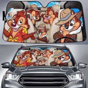 Peut inclure: Pare-soleil de voiture avec une image de dessin animé de Tic et Tac dans une voiture. Le design montre les personnages dans diverses poses, dont un qui conduit. Le fond représente un ciel bleu et des sièges de voiture.