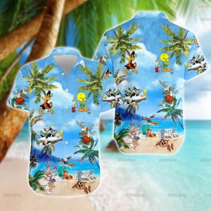 May include: A short-sleeved button-down shirt featuring a tropical beach scene with cartoon characters. The shirt has a light blue background with palm trees, sand, and cartoon characters. The characters include Bugs Bunny, Daffy Duck, and Tweety Bird.