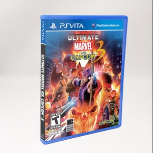 May include: A blue PlayStation Vita game case featuring a red, orange, and yellow image of characters from the video game Ultimate Marvel vs. Capcom 3. The game case has a Teen rating from the ESRB.