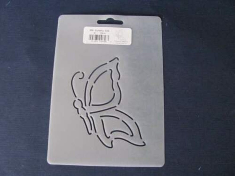 May include: A rectangular, semi-transparent plastic stencil sheet featuring a die-cut butterfly design in the center. A white rectangular label is affixed to the top, displaying the text 358 Butterfly Side 6 inch.