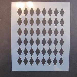 May include: A white stencil with a repeating diamond pattern. The stencil is made of a thin, flexible material and is designed for use with paint or other mediums.