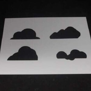 May include: A stencil with four different cloud shapes cut out. The stencil is white and the cloud shapes are black.