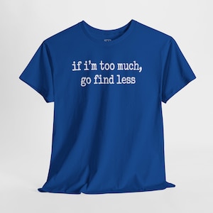 A blue t-shirt with the text "if i'm too much, go find less" printed on it.