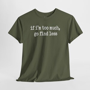 A green t-shirt with the text "if i'm too much, go find less" printed on it.