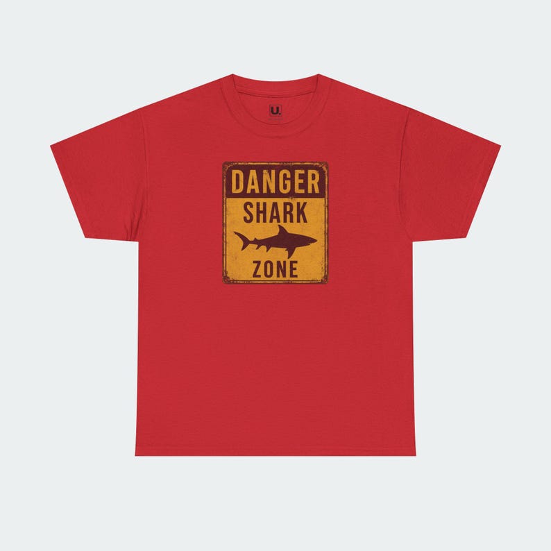 A red t-shirt with a graphic design that says "DANGER SHARK ZONE" in bold letters.