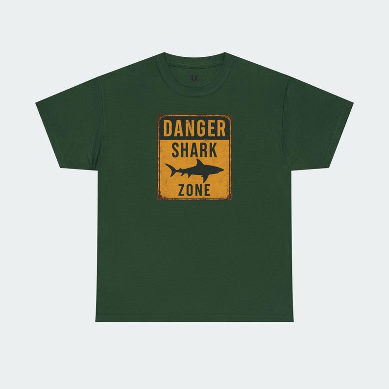 A green t-shirt with a graphic design that says "DANGER SHARK ZONE" in bold letters.