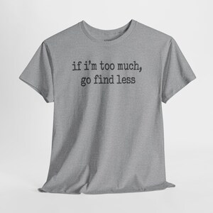 A gray t-shirt with the text "if I'M TOO MUCH, go find less" printed on it.