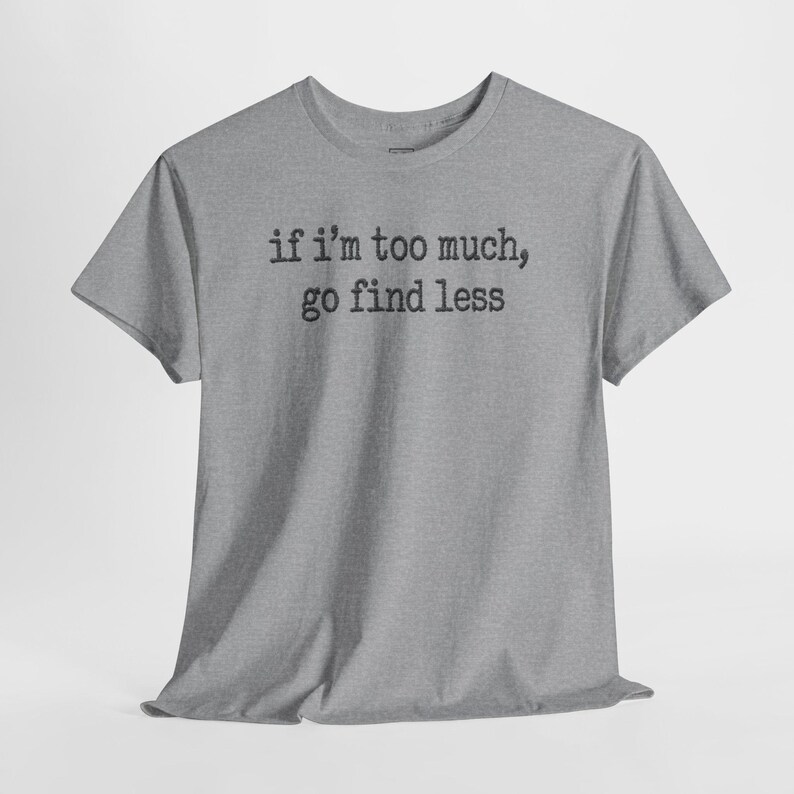 A gray t-shirt with the text "if I'M TOO MUCH, go find less" printed on it.