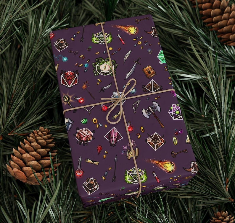 May include: A wrapped gift with a purple background and a repeating pattern of fantasy role-playing game elements. The design includes dice, weapons, potions, and gems. The gift is tied with twine and set against a backdrop of pine needles and pine cones.